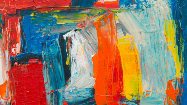 Vibrant abstract paint strokes with bold red orange blue and yellow colors on canvas
