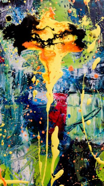 Abstract paint splatter with bright yellow and orange colors on a vibrant textured surface