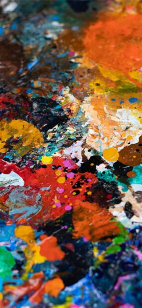 Vibrant paint palette with various colorful strokes and splatters on canvas