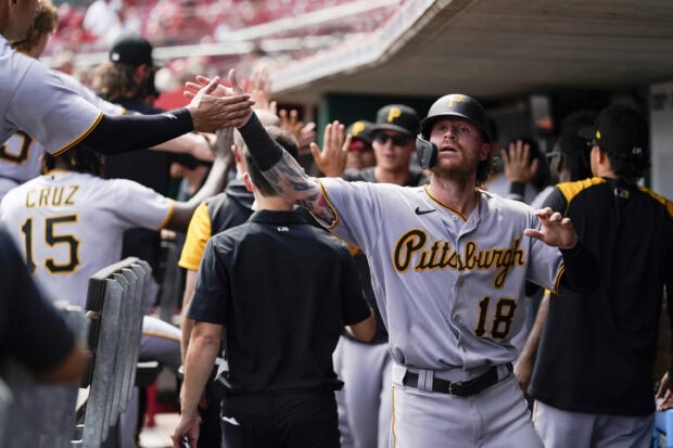 A Pittsburgh Pirates player celebrating with teammates after scoring in a baseball game