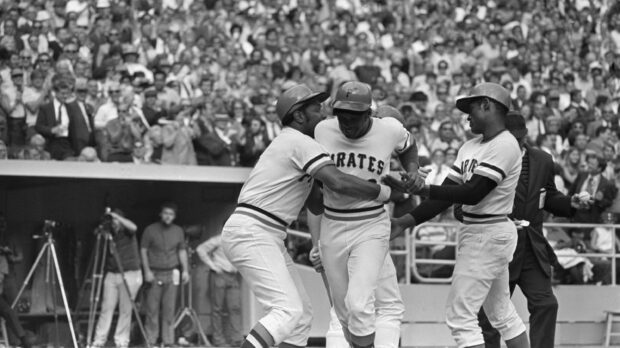 Pittsburgh Pirates players celebrating a game moment on the baseball field in front of a cheering crowd