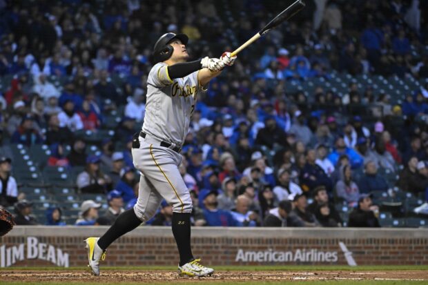 A Pittsburgh Pirates player swings a bat during a baseball game in front of a crowded stadium