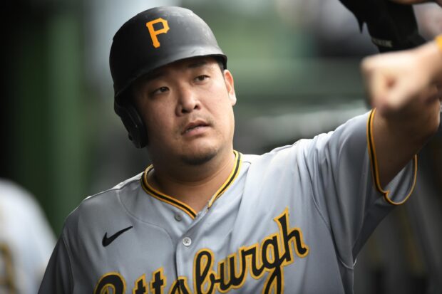 Pittsburgh Pirates player wearing helmet and jersey preparing for game in dugout
