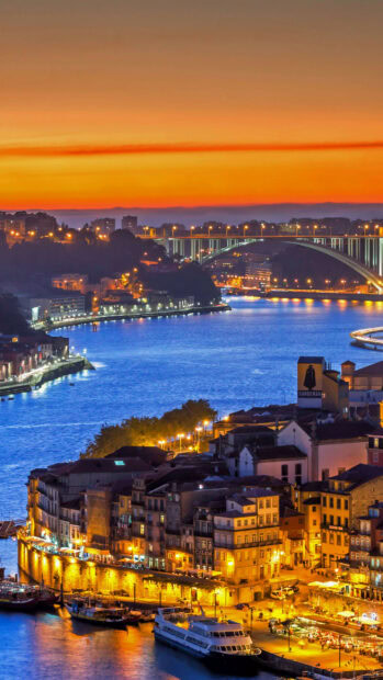 Beautiful Portugal cityscape at sunset showing river and historic buildings illuminated at night