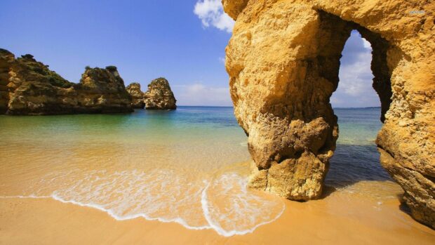 Natural rock formations along the coastline of Portugal with clear water and blue sky