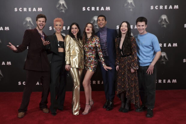 A group of celebrities posing together on a red carpet event for Scream