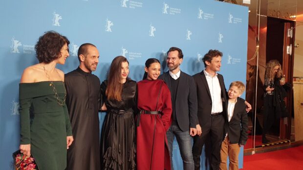 A group of people smiling at a film festival event on the red carpet