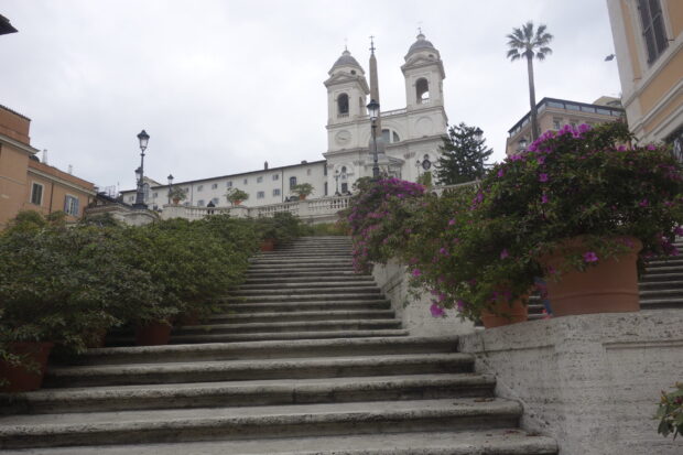 The Spanish Steps with blooming flowers and historic buildings in Rome