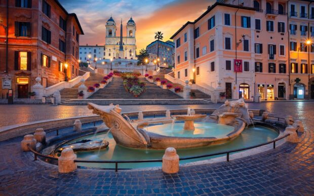 Ancient Spanish Steps in Rome with ornate fountain and historic buildings at sunset