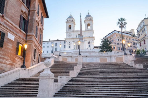 Spanish Steps in Rome with historic architecture and street lamps in clear sky
