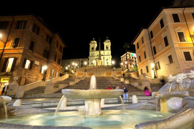 The Spanish Steps Rome at night with illuminated fountain and historic buildings