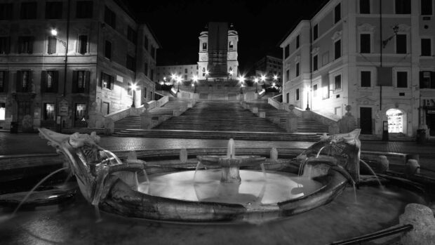 Historic Spanish Steps Rome at night with fountain and surrounding buildings in black and white