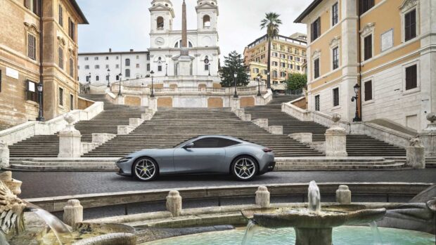 A sleek car parked in front of the historic Spanish Steps Rome in a clear daylight setting