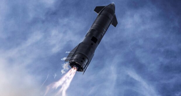 Starship launching into the sky with fiery engine exhaust against a cloudy blue background