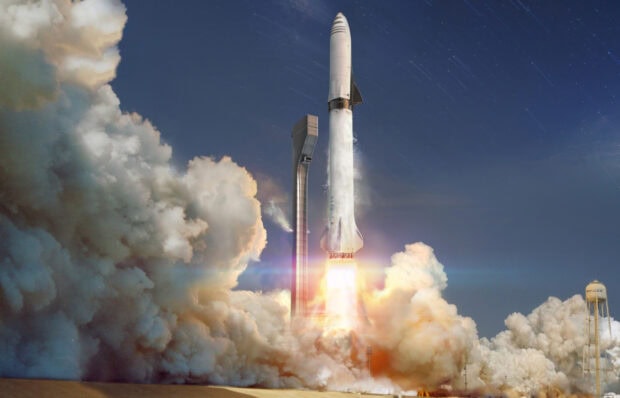 Starship rocket launching into the sky with clouds of smoke and flame at the launch site