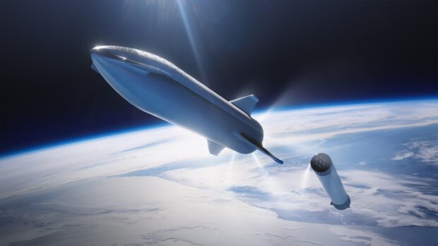 A large starship separating from its booster above Earth in outer space