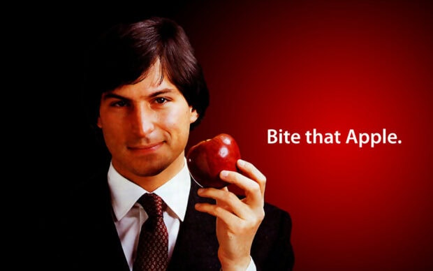 Young Steve Jobs holding an apple with a confident expression on a dark background