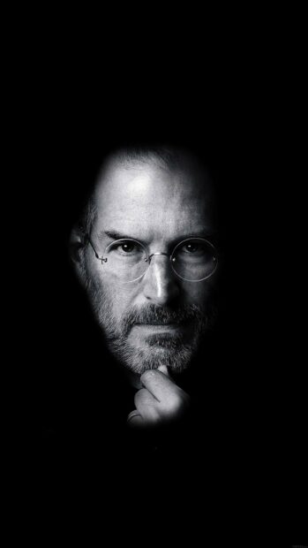 Steve Jobs thoughtful portrait with glasses and beard on black background