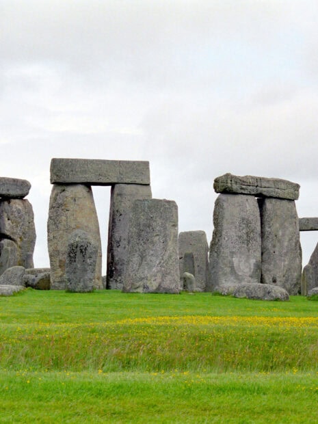 Ancient Stonehenge monument stands tall on lush green grass field