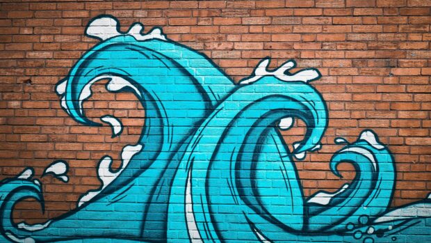 Blue wave street art painted on a brick wall showing urban street art design