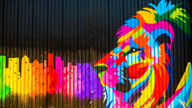 Colorful street art lion with cityscape elements on metal wall