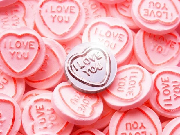 Pink heart shaped sweets with I love you text in a close up view