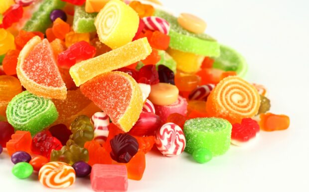 Colorful sweets with various shapes and flavors on a white surface