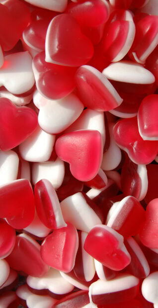 Red and white heart shaped sweets stacked together in close up view