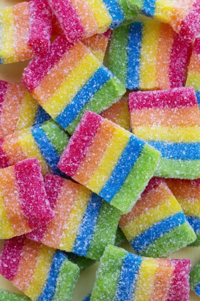 Colorful rainbow candy pieces covered with sugar crystals and striped patterns