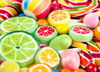 Colorful sweets with citrus fruit designs in a pile of vibrant candies