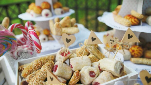 Various sweets with jam filling and sesame seeds decorated with cute paper flags