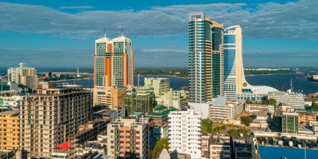 A panoramic view of Tanzania city skyline featuring tall buildings and a river in the background