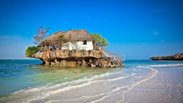 A traditional house on a rocky island along the coast of Tanzania with clear blue ocean