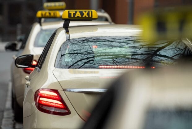 Taxi waiting in a line on the city street with reflections on the rear window