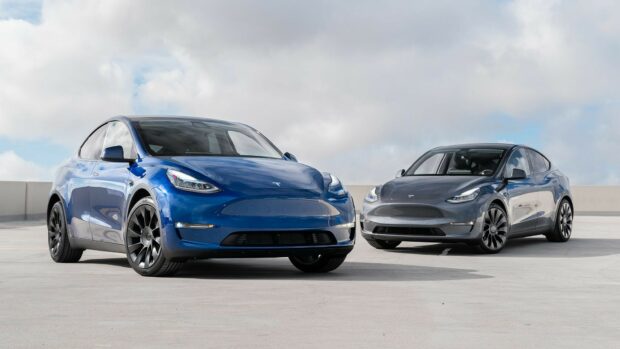 Blue and gray Tesla Model Y cars parked outside under cloudy sky