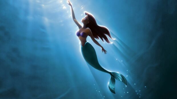 A little mermaid swimming upwards through the ocean light beams