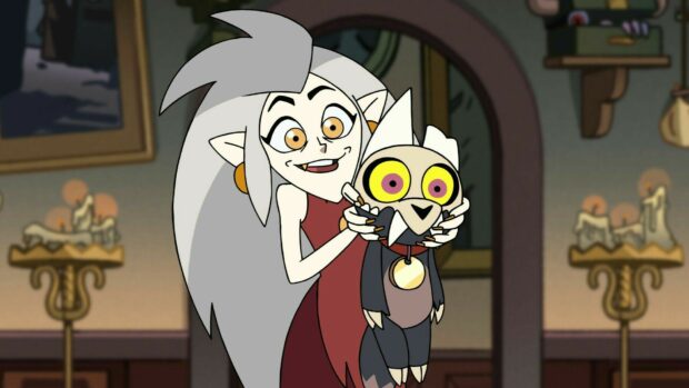 A witch holding a small creature from The Owl House series with a cheerful expression