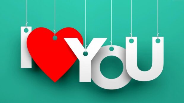 I love you message with a red heart and white letters hanging on strings against green background