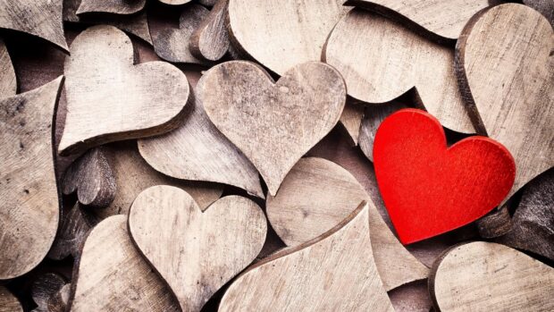 A red heart among many wooden hearts representing Valentine love