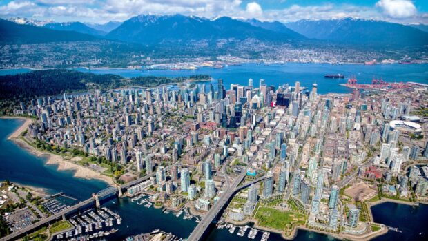Aerial view of Vancouver Canada cityscape with mountains and waterfront in clear weather