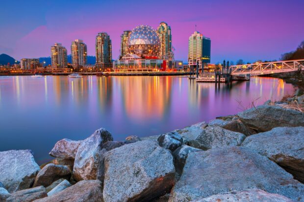 Vancouver Canada skyline with rocks in the foreground reflecting city lights at dusk