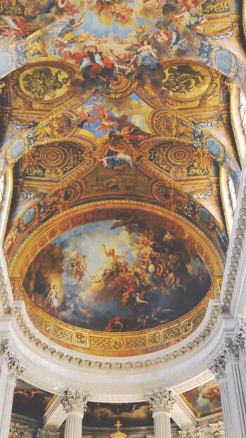 The ceiling fresco of Versailles showcasing elegant golden decorations and classical figures in vibrant colors