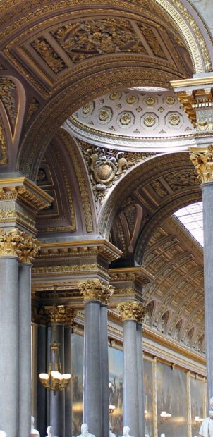 Detailed ornate arches and columns with intricate gold decorations in Versailles palace interior