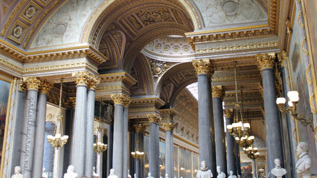 The grand hall of Versailles with detailed columns and ornate decorations in classical style