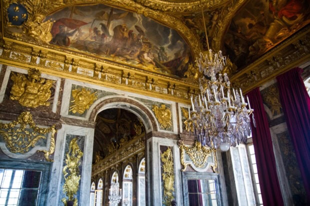The Versailles interior decorated with gold details and a large crystal chandelier