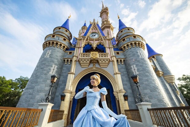 Cinderella posing in front of the Walt Disney World Resort castle at sunset