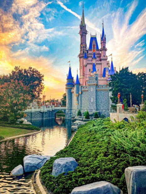 Beautiful Walt Disney World Resort castle with blue towers and sunset sky in the background