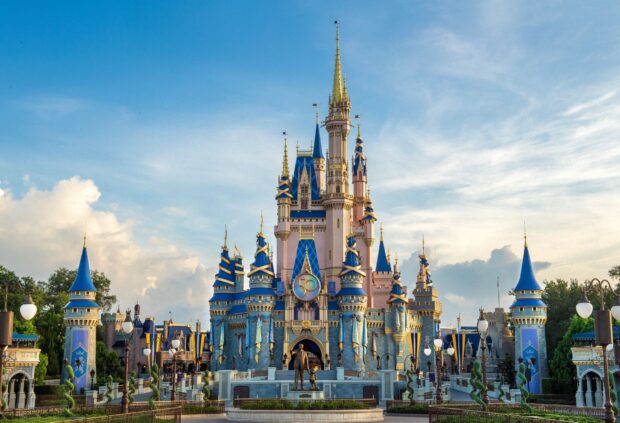 The iconic Walt Disney World Resort castle adorned with blue and gold decorations under a bright sky