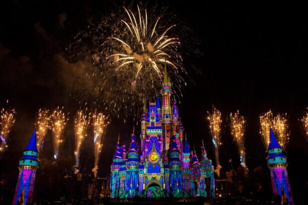 Cinderella Castle lit up at Walt Disney World Resort with fireworks display at night