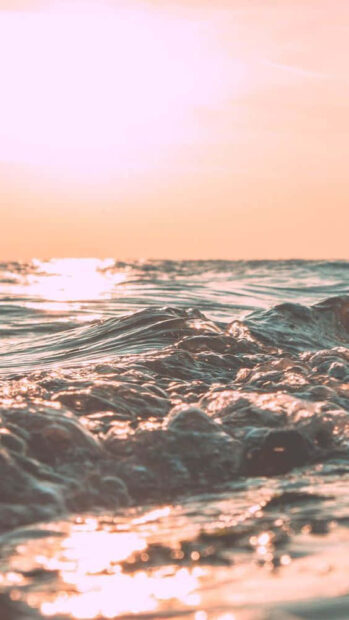 Soft summer sunlight over ocean waves during golden hour